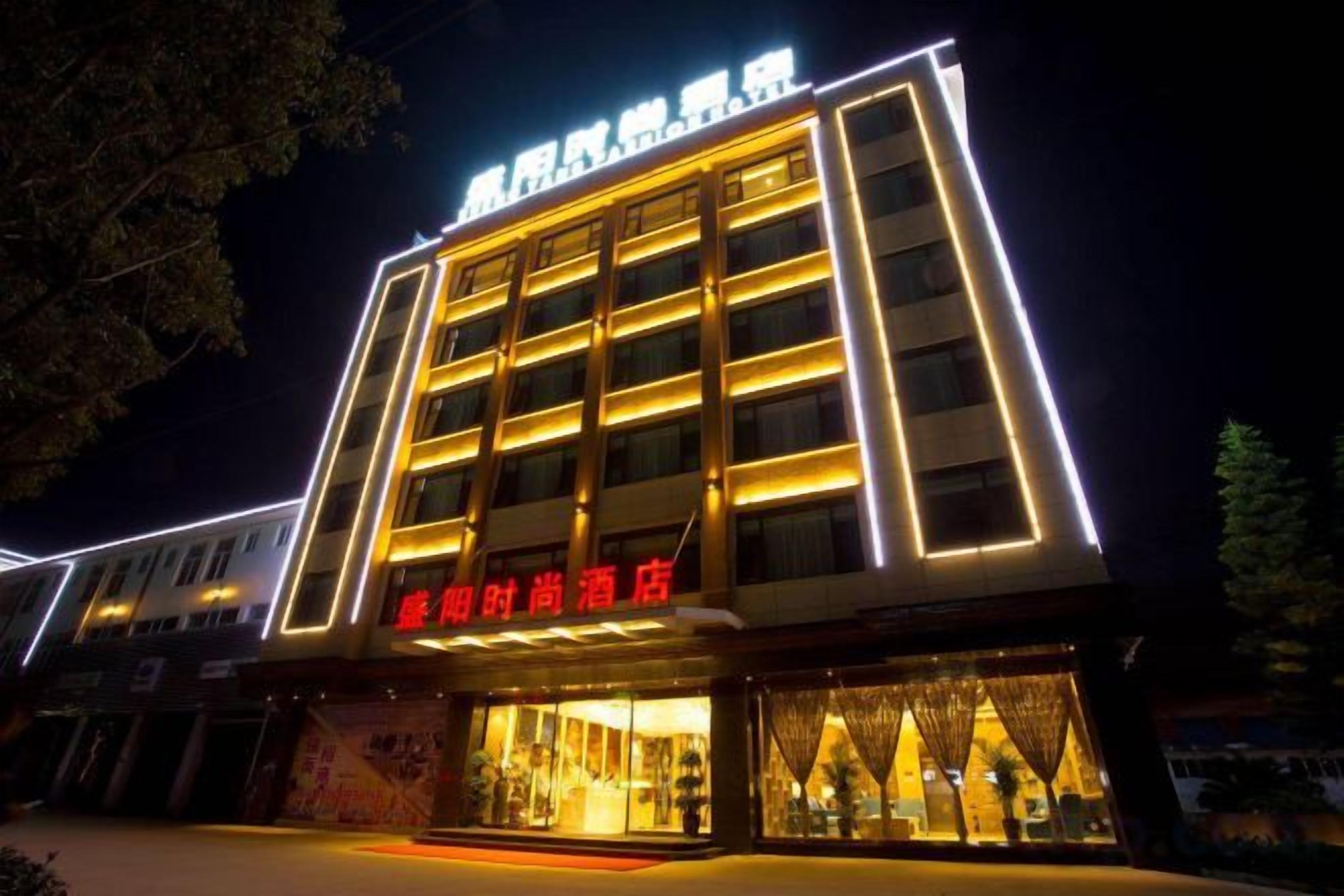 Un hotel a più piani con insegne illuminate e un ingresso ben illuminato.