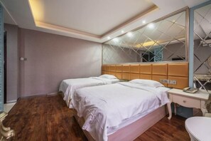 A hotel room with two beds, a large mirror, a wooden floor, and a bedside table with a lamp. - Yueshangchen Boutique Hotel (Xiamen)