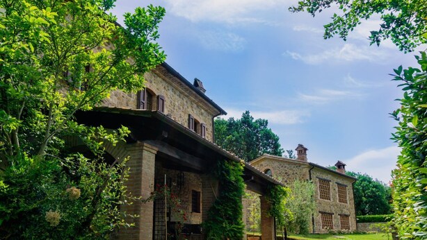 A stone building with a covered porch and a garden. - Villa Comunalia by MMega (Umbertide)