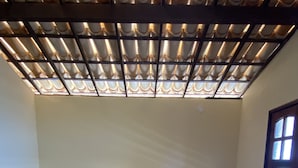 Una cama impecablemente arreglada con ropa de cama floral, cabecera de madera y ventana con vistas.