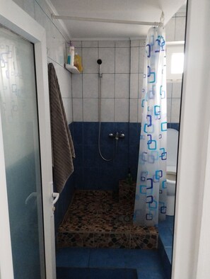 Een douche, handdoeken, toiletpapier