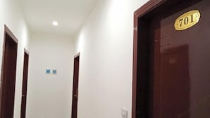 Un pasillo con una puerta identificada con el número 701 e interruptor de luz en la pared.