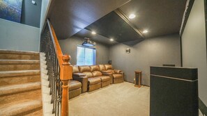A home interior with a staircase, a leather couch, a speaker, and a carpeted floor. - Beautiful 3 bedroom home with theater! (Littleton)