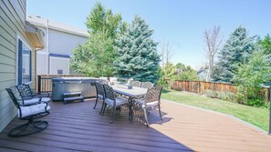 A deck with a hot tub, outdoor furniture, and a wooden fence. - Beautiful 3 bedroom home with theater! (Littleton)