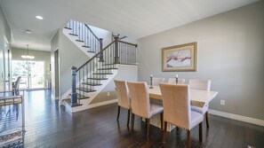 A dining area with a staircase, wooden flooring, and a framed artwork on the wall. - Beautiful 3 bedroom home with theater! (Littleton)
