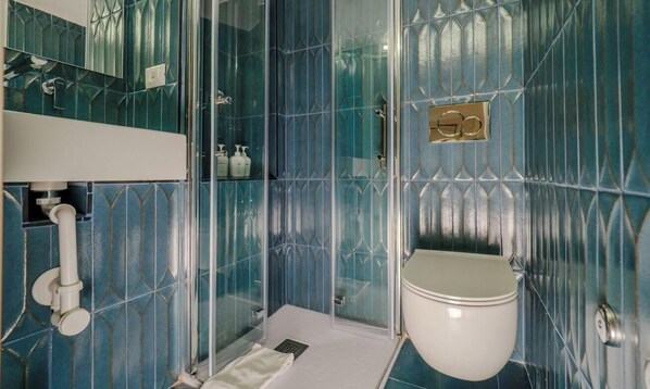 A bathroom with a glass shower enclosure, a toilet, and a sink. - Picagetta Tiny Room, one of the smallest and most comfortable rooms in Vernazza (Vernazza)