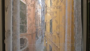 A window with a floral pattern and a yellow building outside. - Picagetta Tiny Room, one of the smallest and most comfortable rooms in Vernazza (Vernazza)