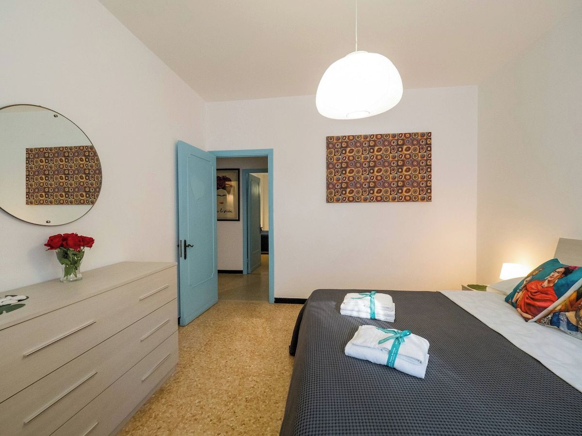 Une chambre d’hôtel comprenant un lit, une commode, un miroir et une porte donnant sur une autre pièce.