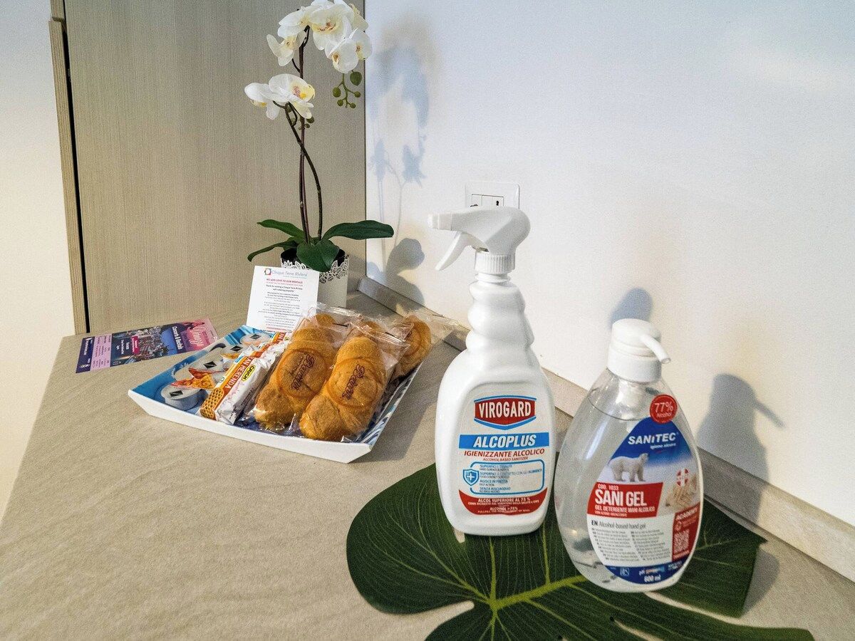 Une table sur laquelle se trouve un plateau de viennoiseries, un vaporisateur étiqueté « VIROGARD ALCOPLUS » et une bouteille de « SANITEC SANI GEL ».