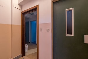 A hallway with a door leading to a room.