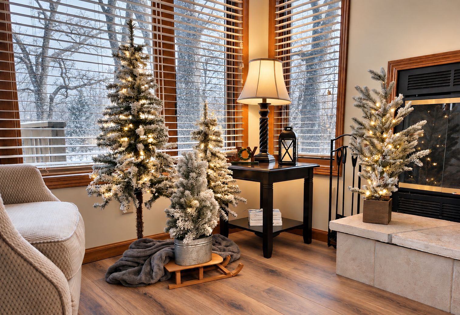 A cozy living room with a fireplace, a small table with a lamp, and two artificial Christmas trees.