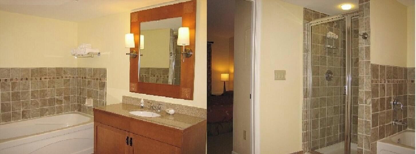 A bathroom with a bathtub, a sink with a mirror, and a shower area.