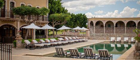 Alberca al aire libre y camas balinesas gratuitas