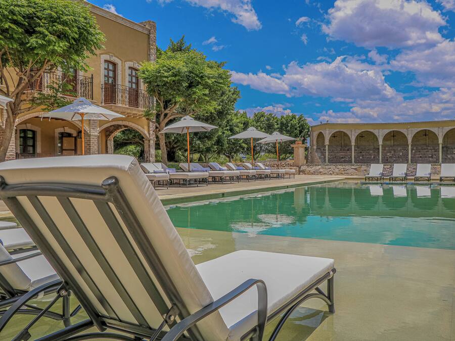 Una piscina al aire libre, camas de piscina gratis, sombrillas