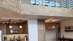 Eine geräumige Küche mit Essbereich, einer Couch und einem Balkon.