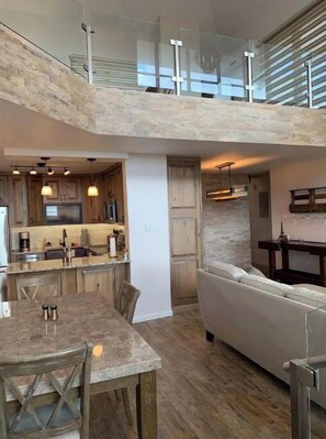 Spacious living area with a central kitchen, dining table, and comfortable seating.