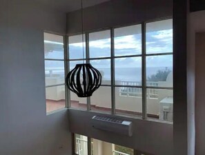 Enjoy a room with a large window offering a view of the sky and distant buildings.