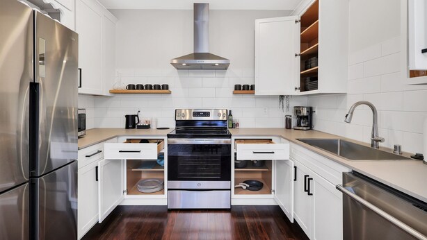 A modern kitchen with white cabinets, stainless steel appliances, and a wooden countertop. - Summit Lofts, Extra Large Executive Suite, #210 (Mt. Shasta)