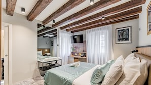 A bedroom with a bed, a desk, a TV, and a window with curtains. - Makarun Heritage Rooms (Split)