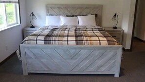Une chambre à coucher avec un lit, deux tables de chevet et une fenêtre.
