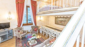 Un salon spacieux équipé d’une télévision, de deux canapés, d’une table basse et d’un coin repas avec des chaises et une table.
