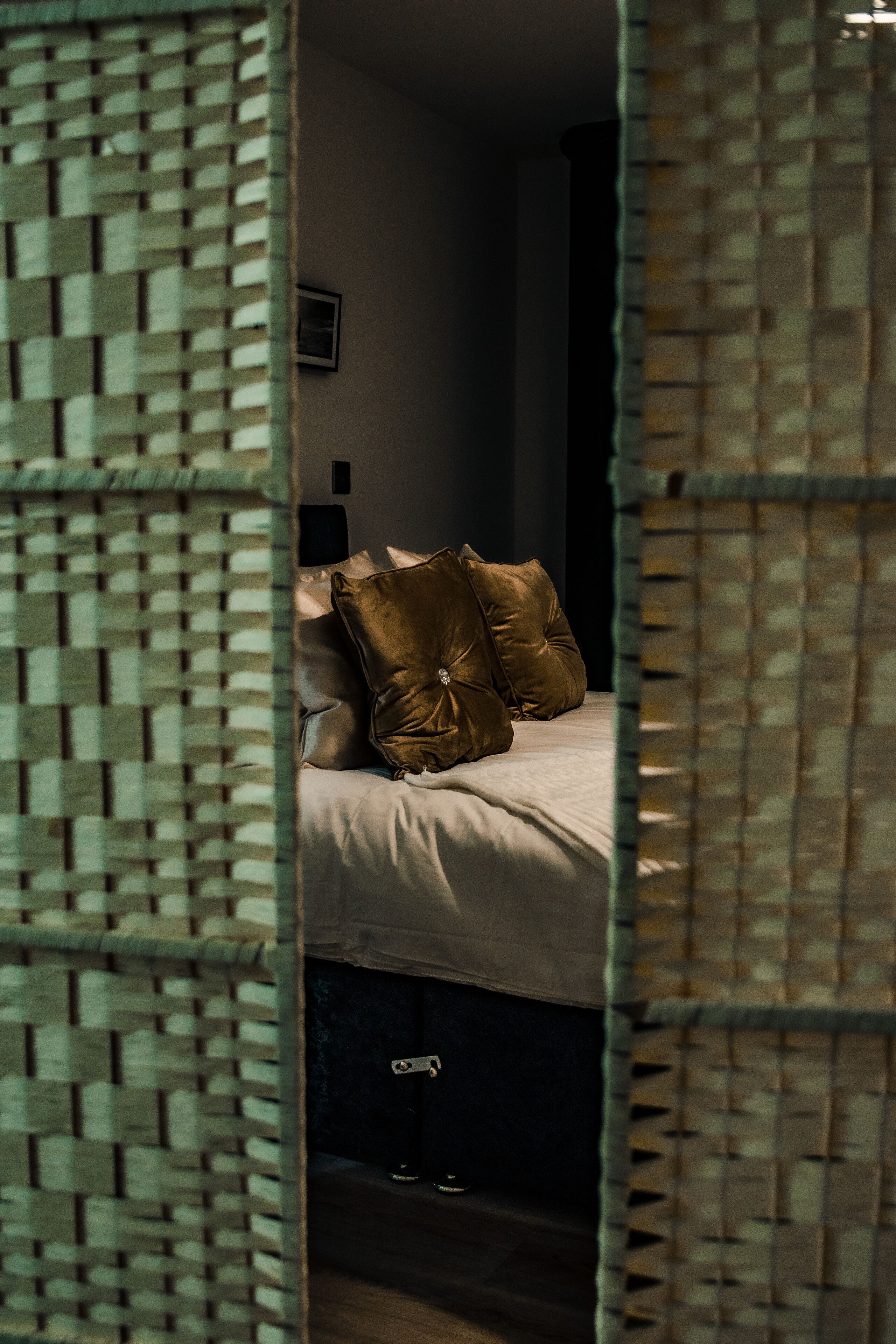 A bedroom with a bed, pillows, and a nightstand.