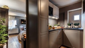 A modern kitchen with grey cabinets, a built-in oven, and a window. - Casa Palatial in Lucca (Lucca)