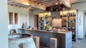 A modern kitchen with a central island, wooden beams on the ceiling, and various kitchen appliances and utensils. - Palazzo Giusti in Pescaglia (Pescaglia)