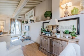 Un salon avec un meuble en bois, un canapé et une table basse.