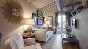 Ein gemütliches Wohnzimmer mit einem großen Spiegel im Sonnenstrahl-Design, einem bequemen Sofa, einem weichen Sessel und einem Holztisch.