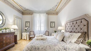 A bedroom with a large bed, a dresser, a mirror, and a window with curtains. - Casa Barbra in Lucca (Lucca)