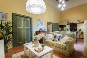 A cozy living room with a green sofa, a white coffee table, and a large window. - Casa Beatrice in Lucca (Lucca)