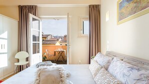 A bedroom with a bed, a bedside table, a chair, and a view of the outside. - Casa Cachi 2 in Lucca (Lucca)