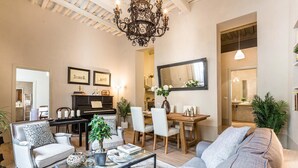 A living room with a piano, a dining table, and a sofa. - Casa Janca in Lucca With 1 Bedrooms and 2 Bathrooms (Lucca)