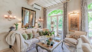 Een gezellige woonkamer met een bank, fauteuils, een salontafel en decoratieve objecten.