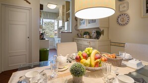 A dining area with a table set for breakfast, including fruits, bread, and tea sets. - Casa Emy in Lucca With 3 Bedrooms and 2 Bathrooms (Lucca)
