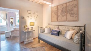 A cozy room with a bed, a bedside table with a lamp, a mirror, and wall-mounted decorative items. - Casa Monique in Lucca (Lucca)