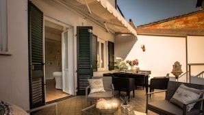 A cozy outdoor seating area with a glass table, wicker chairs, and a sofa. - Casa Raffa in Lucca With 2 Bedrooms and 2 Bathrooms (Lucca)