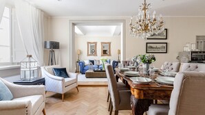 A spacious living room with a dining area, a chandelier, and a view into the kitchen. - Casa San Frediano in Lucca (Lucca)