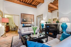 A living room with a sofa, coffee table, fireplace, and decorative items. - Casa Simonetta in Lucca (Lucca)