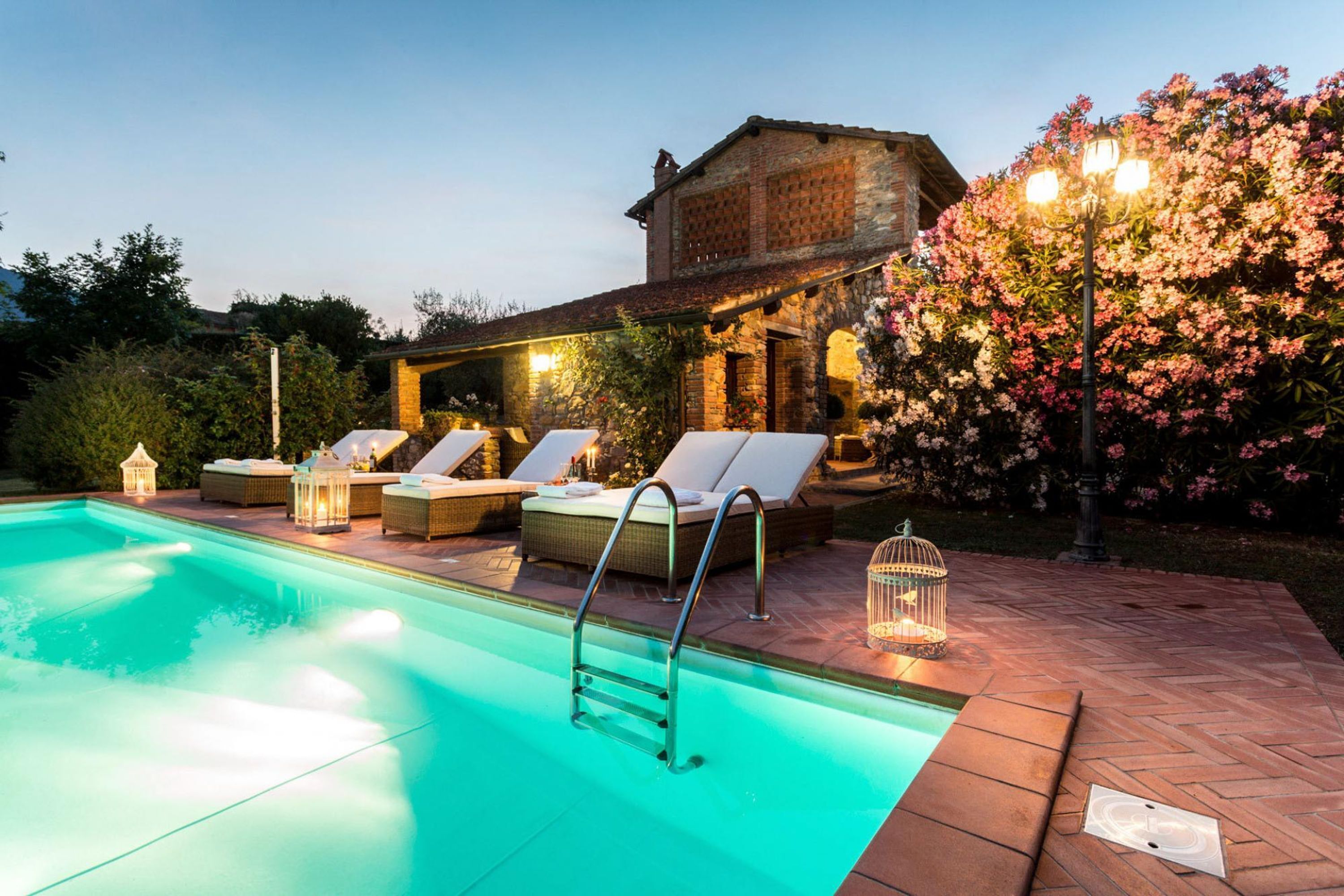A swimming pool with lounge chairs and a wooden deck.
