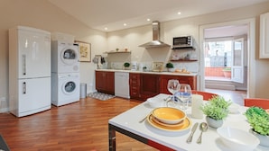 Uma cozinha moderna com área de refeições, apresentando forno embutido, micro-ondas e lava-louças.