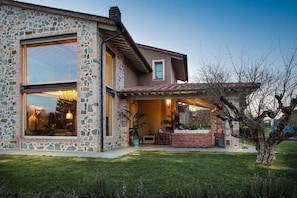A modern house with a stone facade, large windows, and a covered patio area. - Villa Otto in Orentano (Castelfranco di Sotto)