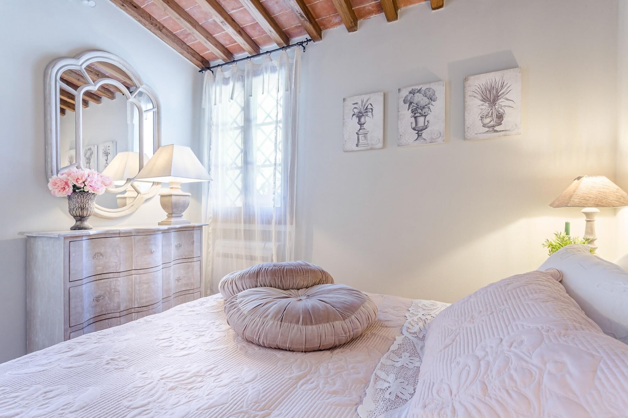 Una camera da letto con un letto, una cassettiera, uno specchio e decorazioni alle pareti.