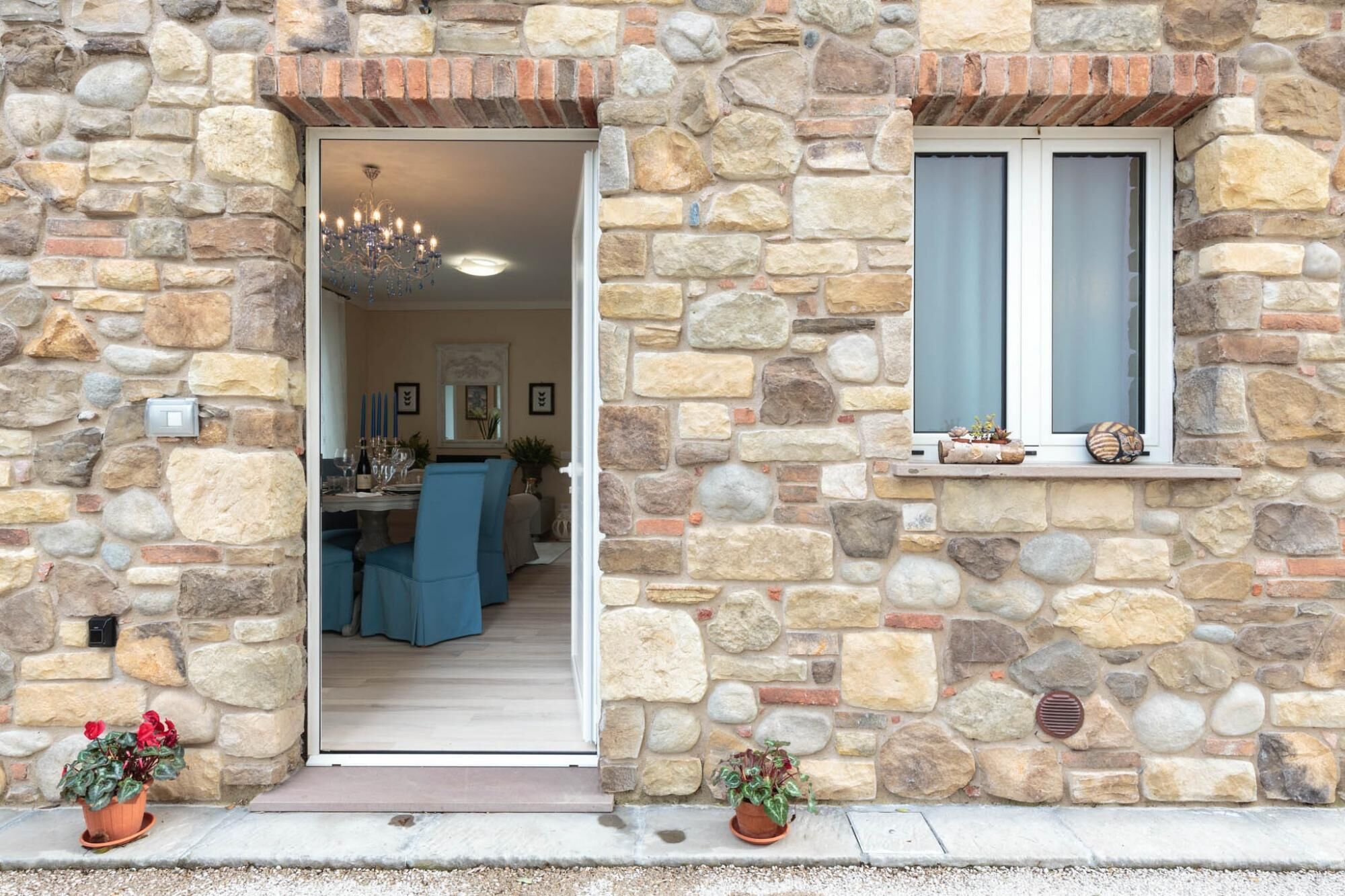 Un edificio in pietra con una sala da pranzo visibile attraverso un'apertura.