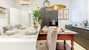 Une cuisine moderne avec un coin repas, comprenant une table en bois, des chaises et un vase avec des fleurs.
