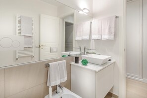 A modern bathroom with two sinks, a large mirror, and a bathtub. - The Palace View in Lucca (Lucca)