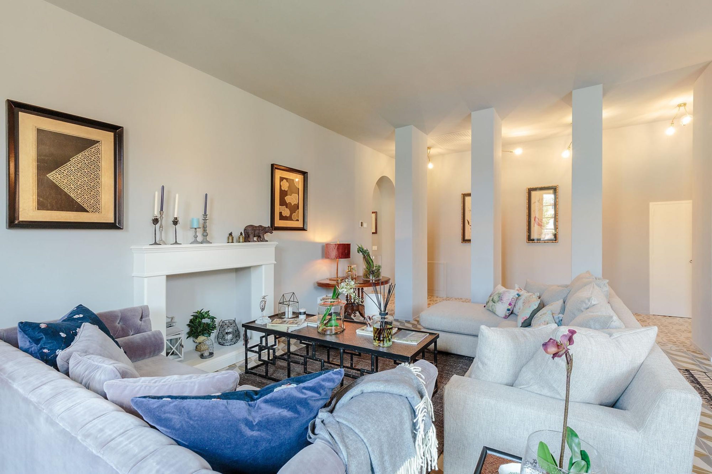 Una sala de estar moderna con chimenea, sofás y una mesita de centro.