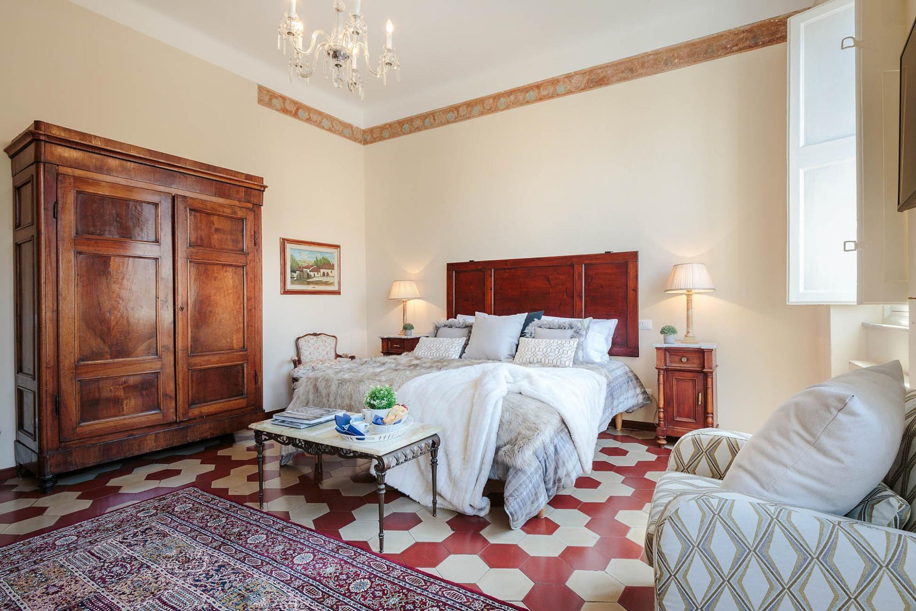 Camera da letto con un letto grande, un'armadio in legno e un tappeto decorato.