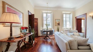 A spacious living room with a sofa, a dining table with chairs, and a lamp. - Casa Santa Croce in Lucca (Lucca)